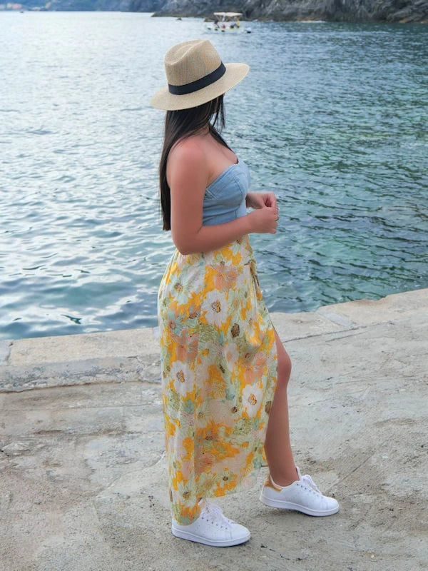 Woman wearing a floral summer skirt and blue bustier. 