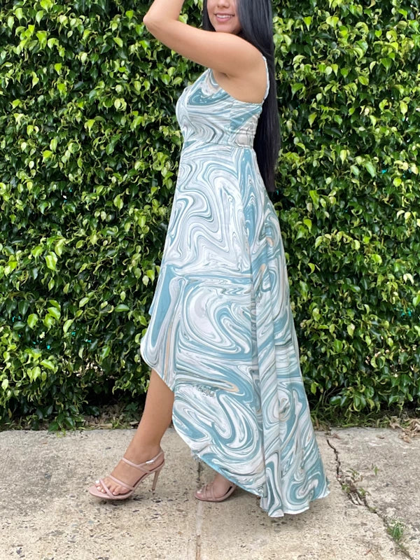 Side view of a high-low asymmetrical dress in marble print. 