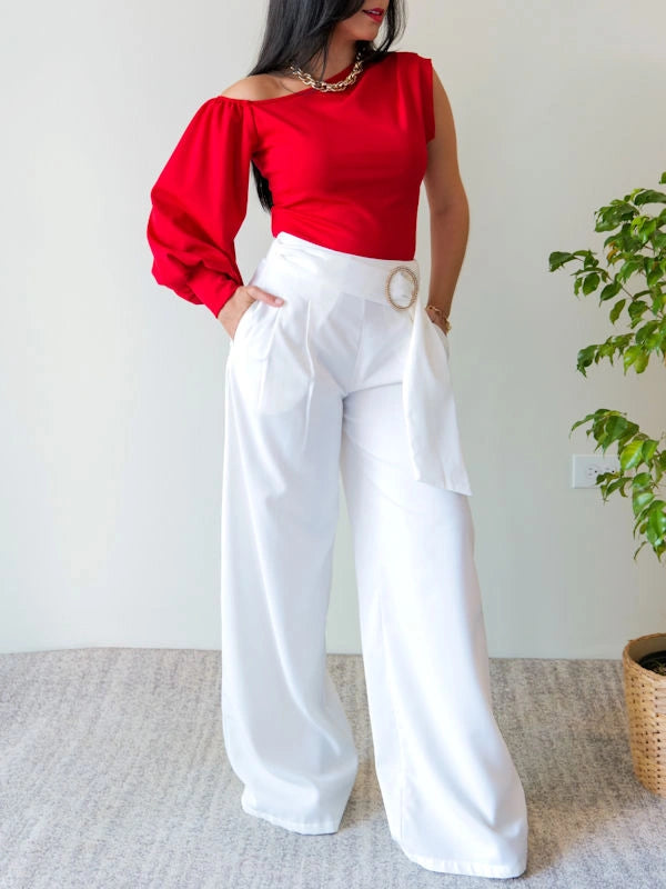 Image of a woman wearing a ladies red evening top and white trousers. 