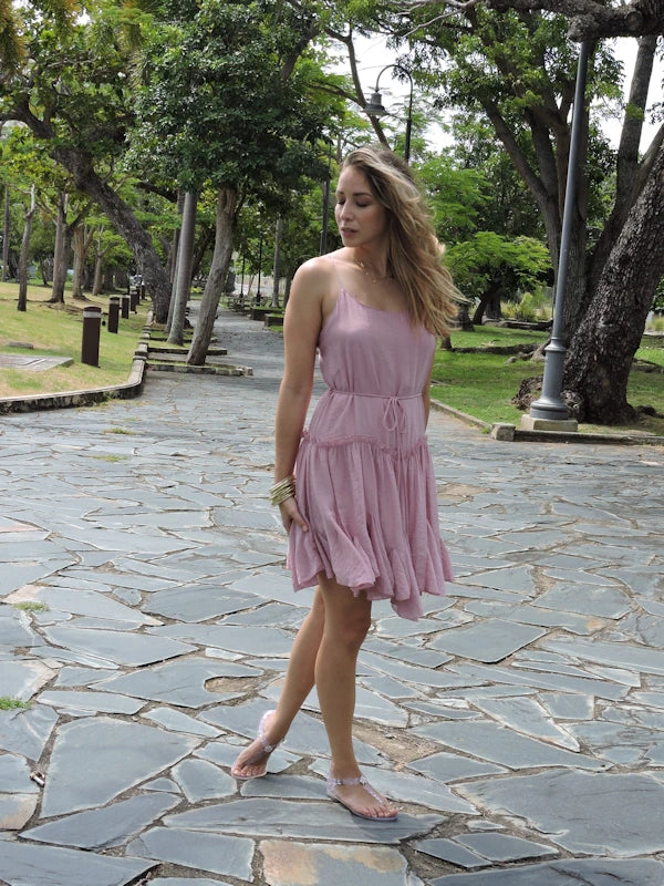  Woman modeling the pink flowy short dress in a park.