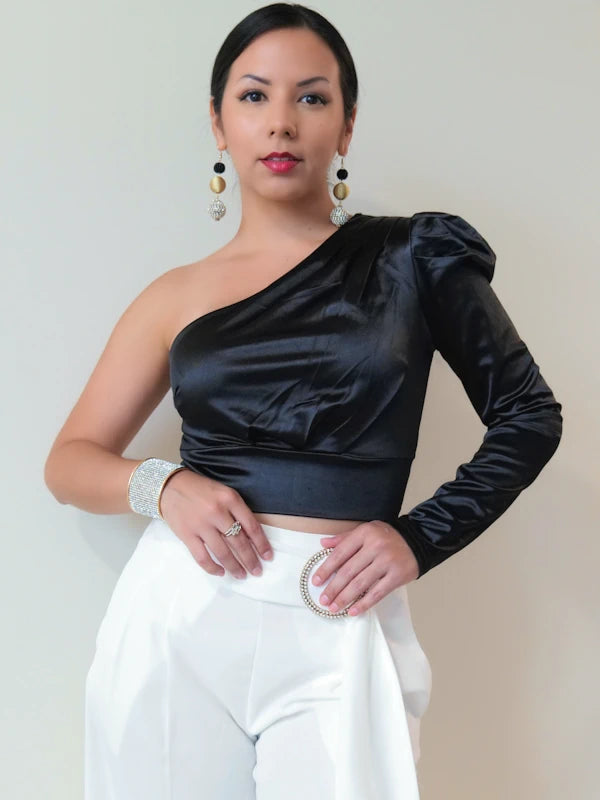 Woman wearing a black dressy crop top and white pants. 