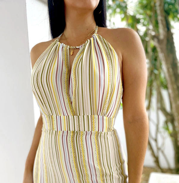  Close-up of a striped sheer halter maxi dress, showing the subtle keyhole detail and vibrant vertical stripes in shades of yellow, cream, and maroon.